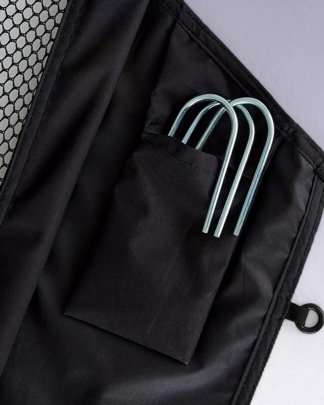Schwarze Tasche mit Netz und silbernen, gebogenen Metallstangen in einer Innentasche.