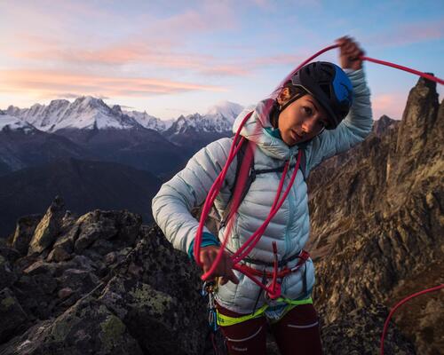 Alpinista a enrolar corda