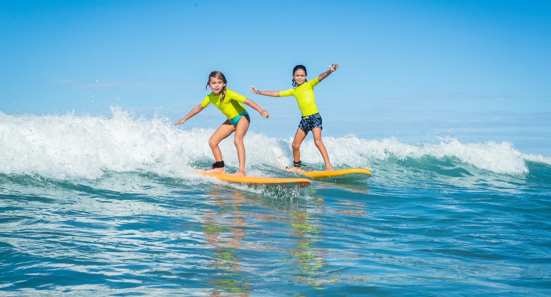 Kinder mit UV-Shirt am Surfen