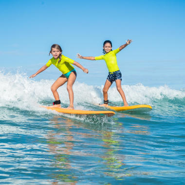 Kinder mit UV-Shirt am Surfen