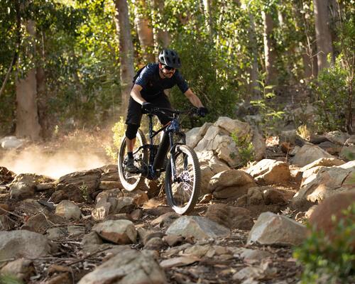 A man riding his mountain bike over rocky terrain
