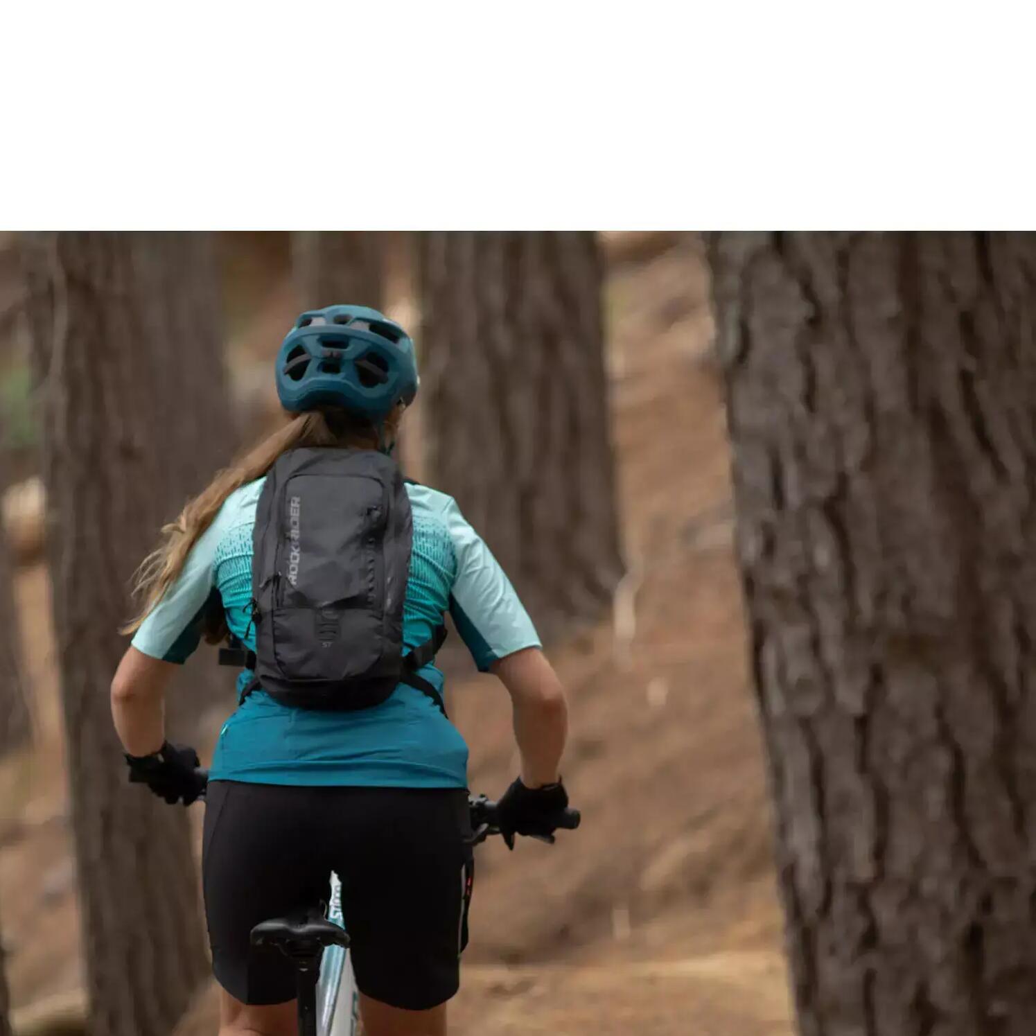 mulher com mochila decathlon praticando btt