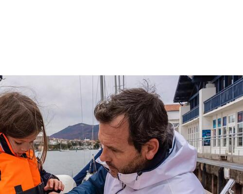 Man putting a life jacket on a child
