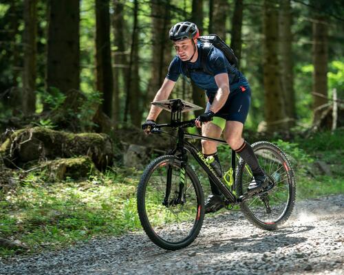 Mann fährt mit Mountainbike durch den Wald