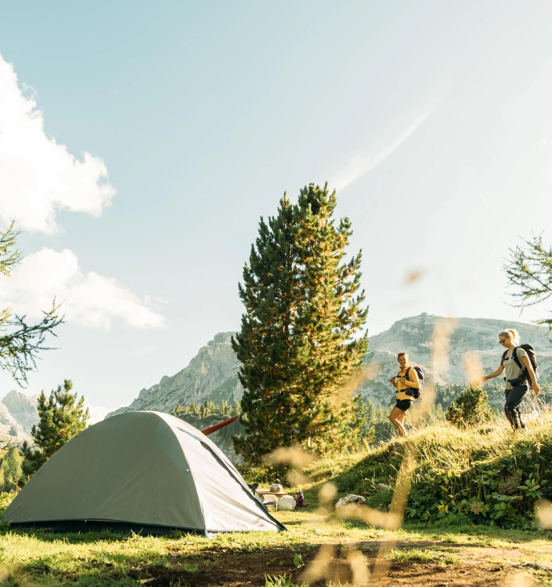 Two hikers walking back to their tent