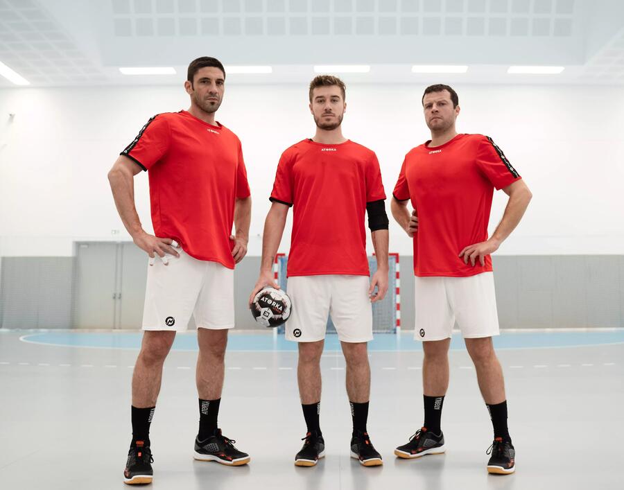 Drei Handballspieler in Trikotsatz stehen nebeneinander