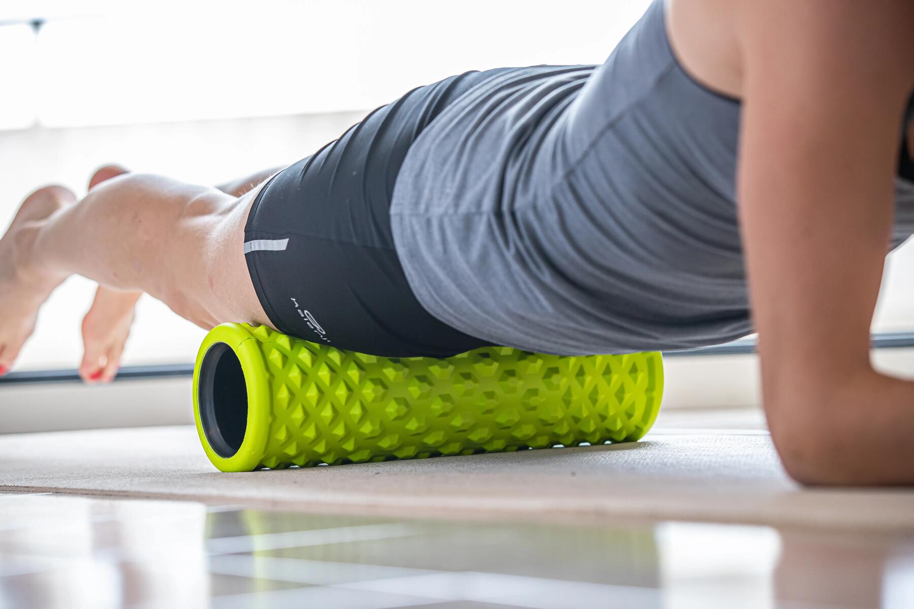 mujer liberando cuadriceps con foam roller
