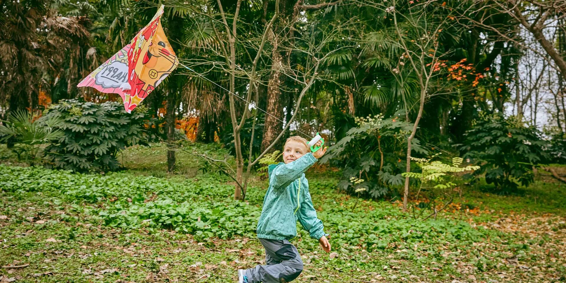 Chłopiec puszczający latawiec w ogrodzie