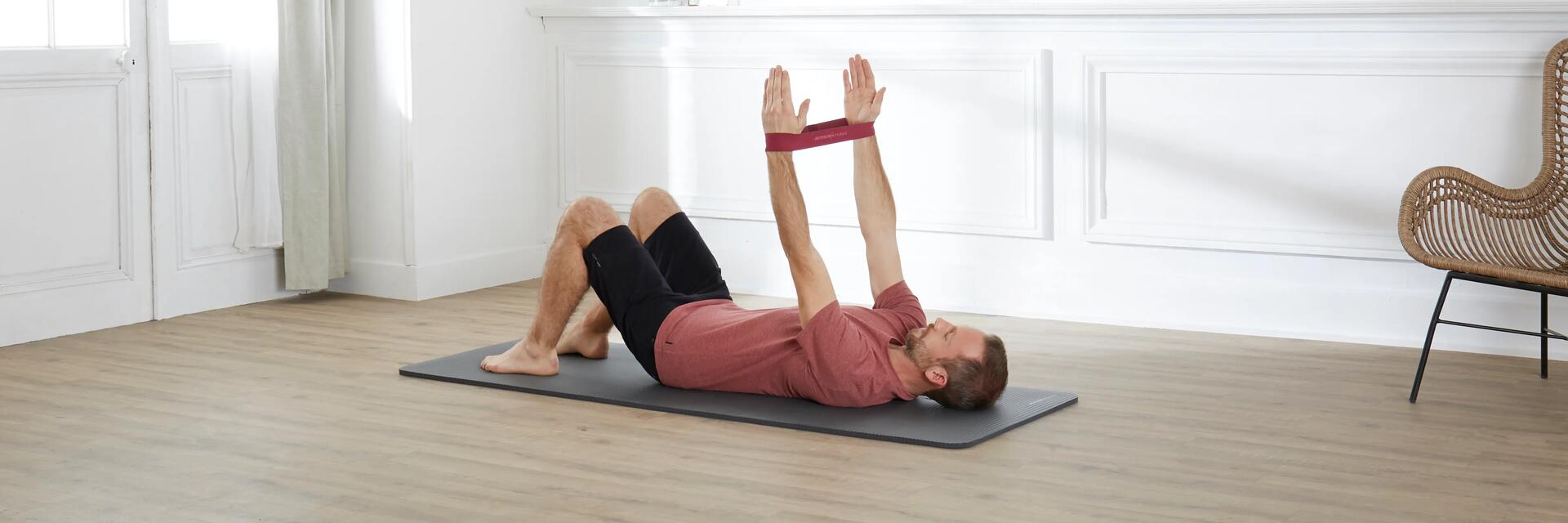 Mężczyzna trenujący pilates z gumą do ćwiczeń