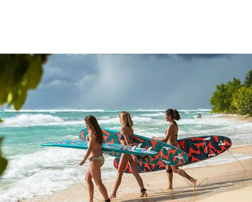 3 kobiety z deskami surfingowymi idą do morza na plaży