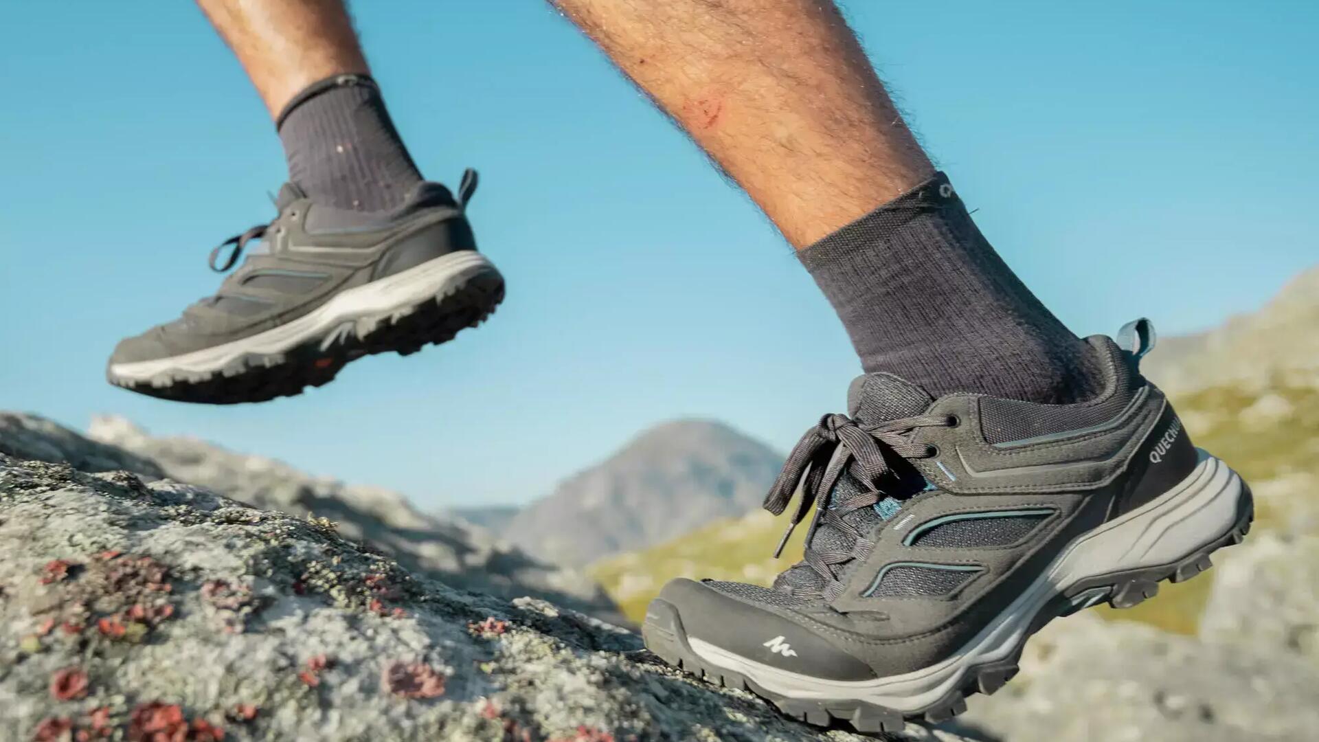 Close up va wandelschoenen en sokken tijdens het wandelen op steen