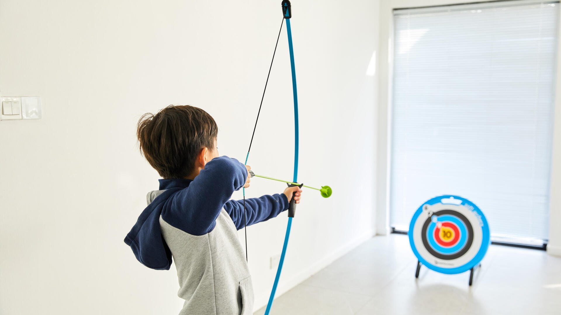 petit garçon qui vise la cible avec son arc à flèche tir à l'arc