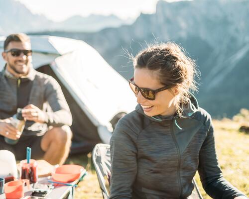 Two people camping wearing sunglasses