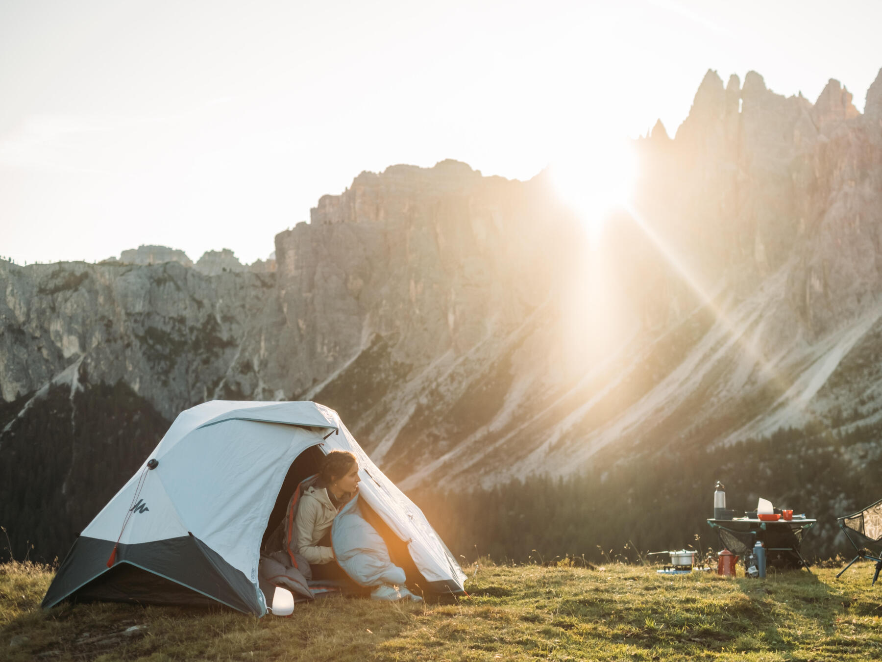 Campeuses sortant de sa tente installée en montagne, au levé du soleil