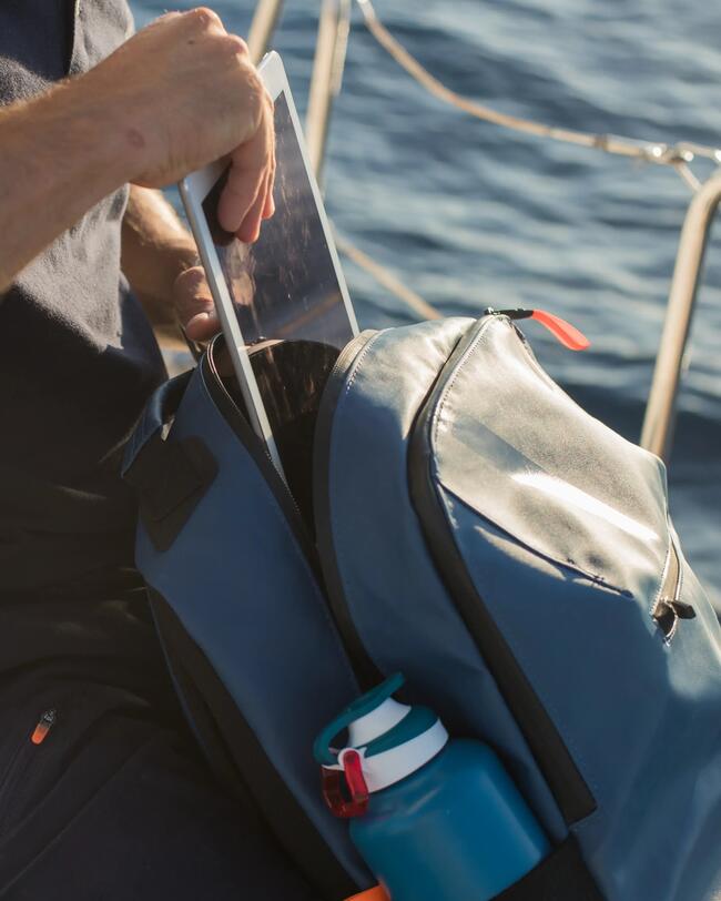 Mann mit blauer Tasche auf Boot, reflektierendes Wasser im Hintergrund, Sonnenlicht, blauer Himmel, entspannte Atmosphäre.