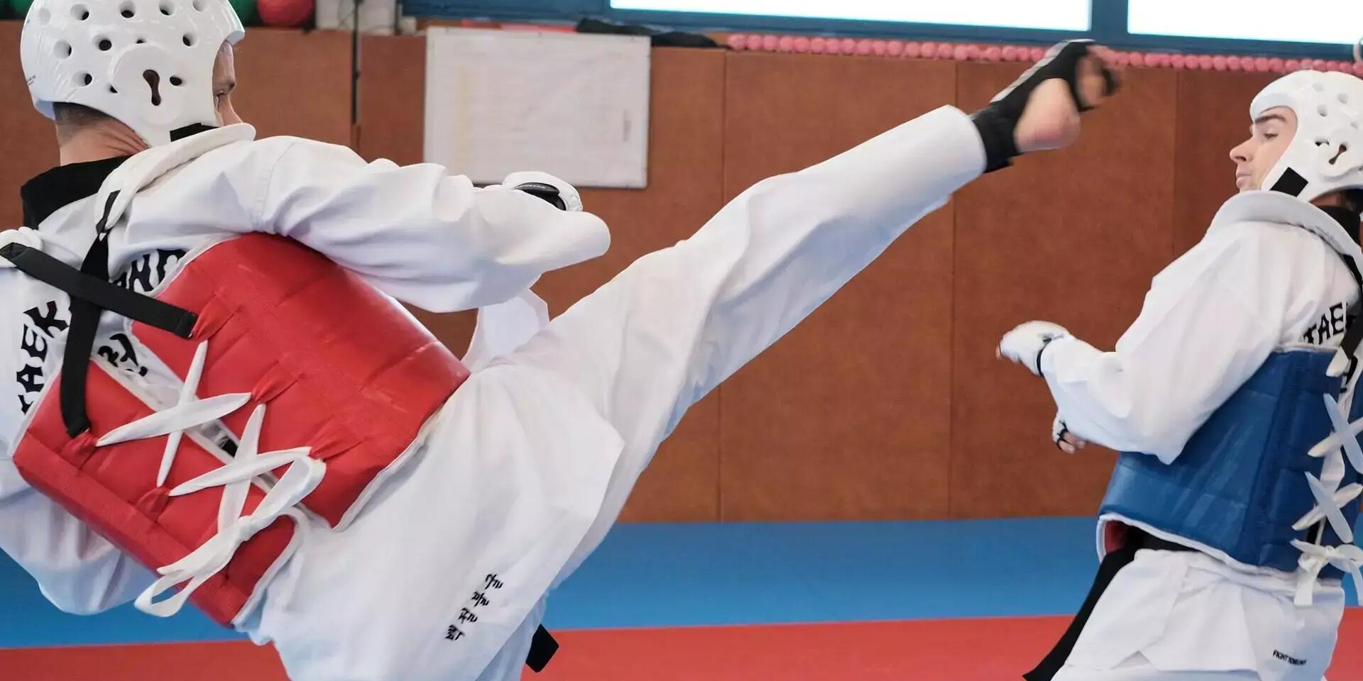 mężczyźni trenujący w kaskach i strojach do taekwondo