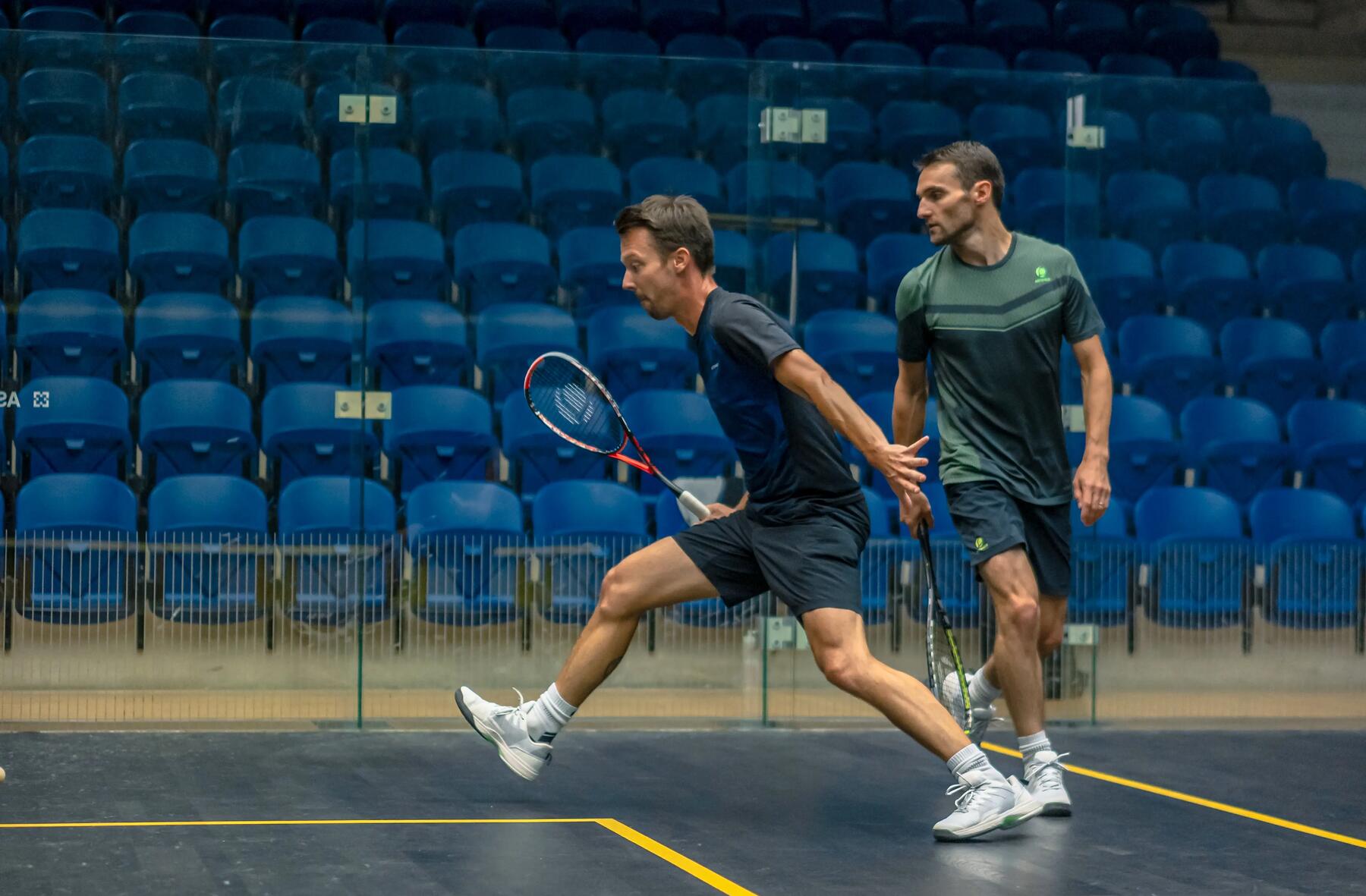 two people playing squash on a squash court