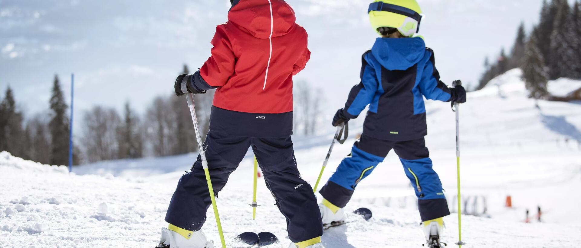 2 kids on the skis going down the slope