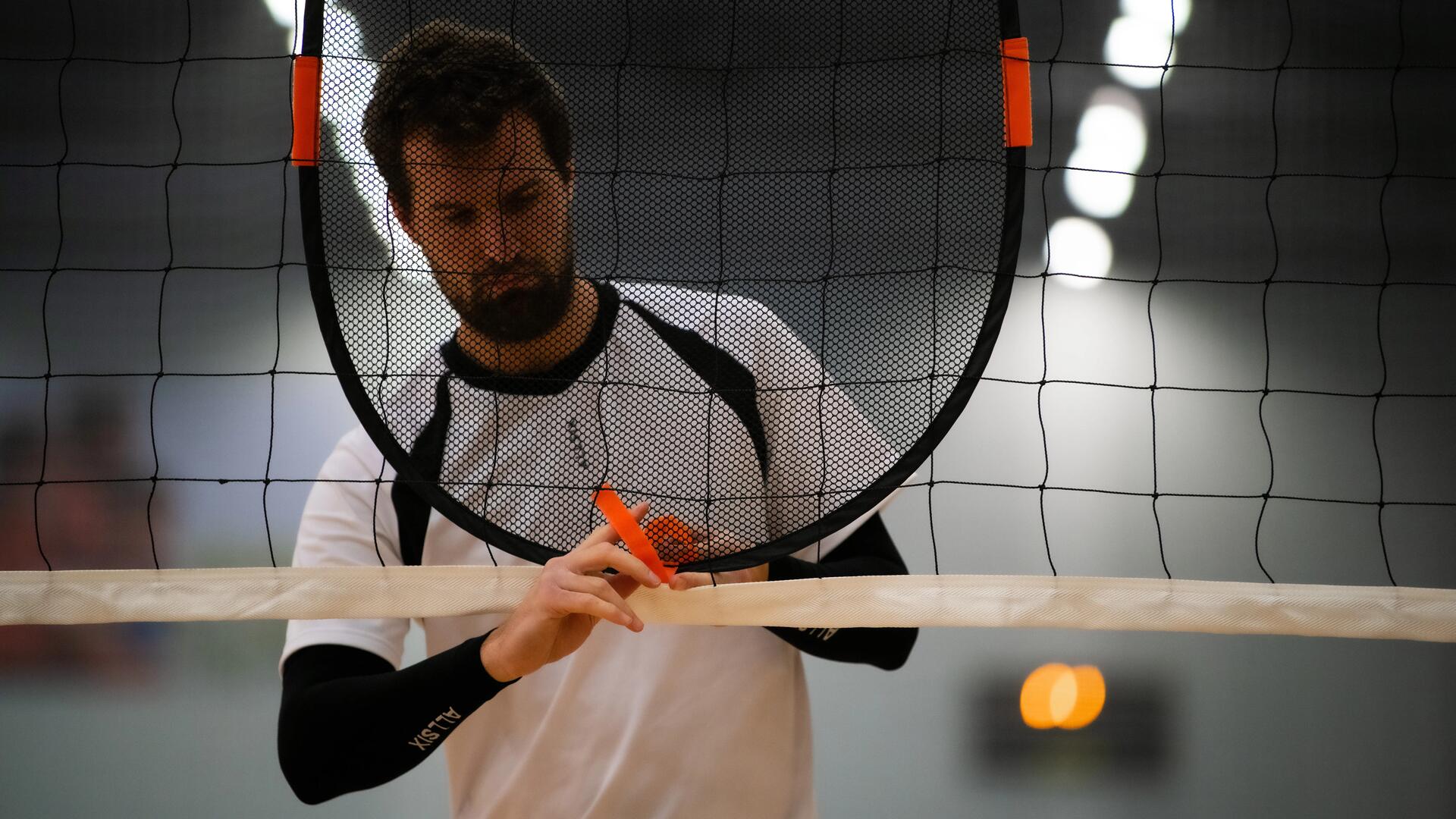 entraineur de volley-ball attachant une cible d'entrainement au filet