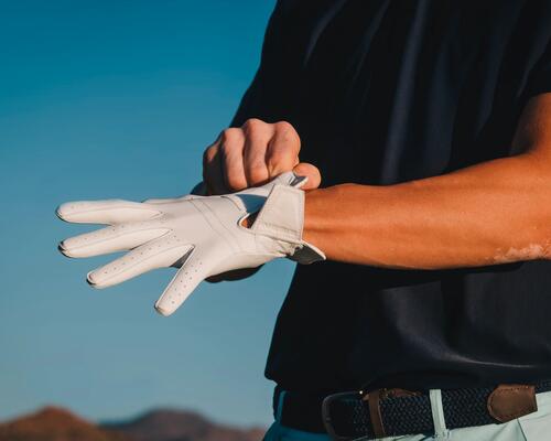 Mann streift sich Golfhandschuh über