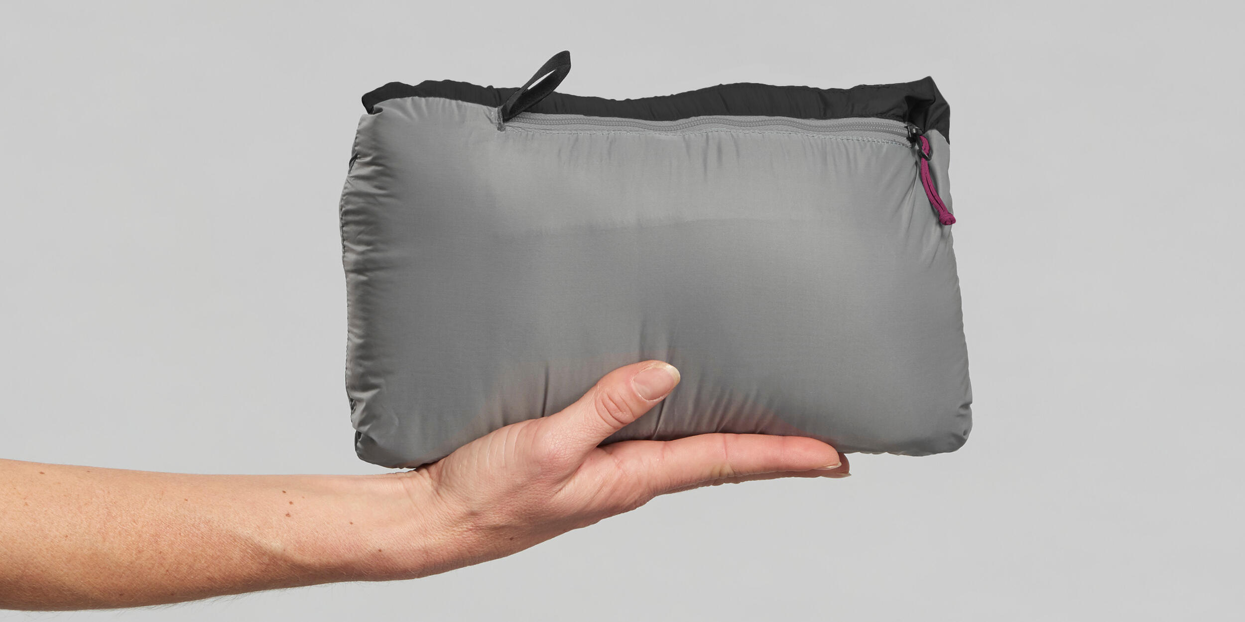 Die Daunenjacke in ihre Tasche packen 