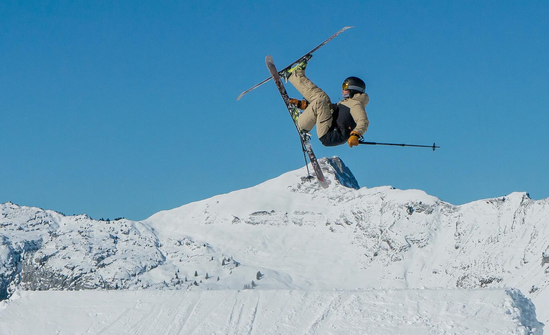 A freeride skier performing a trick on a ski jump