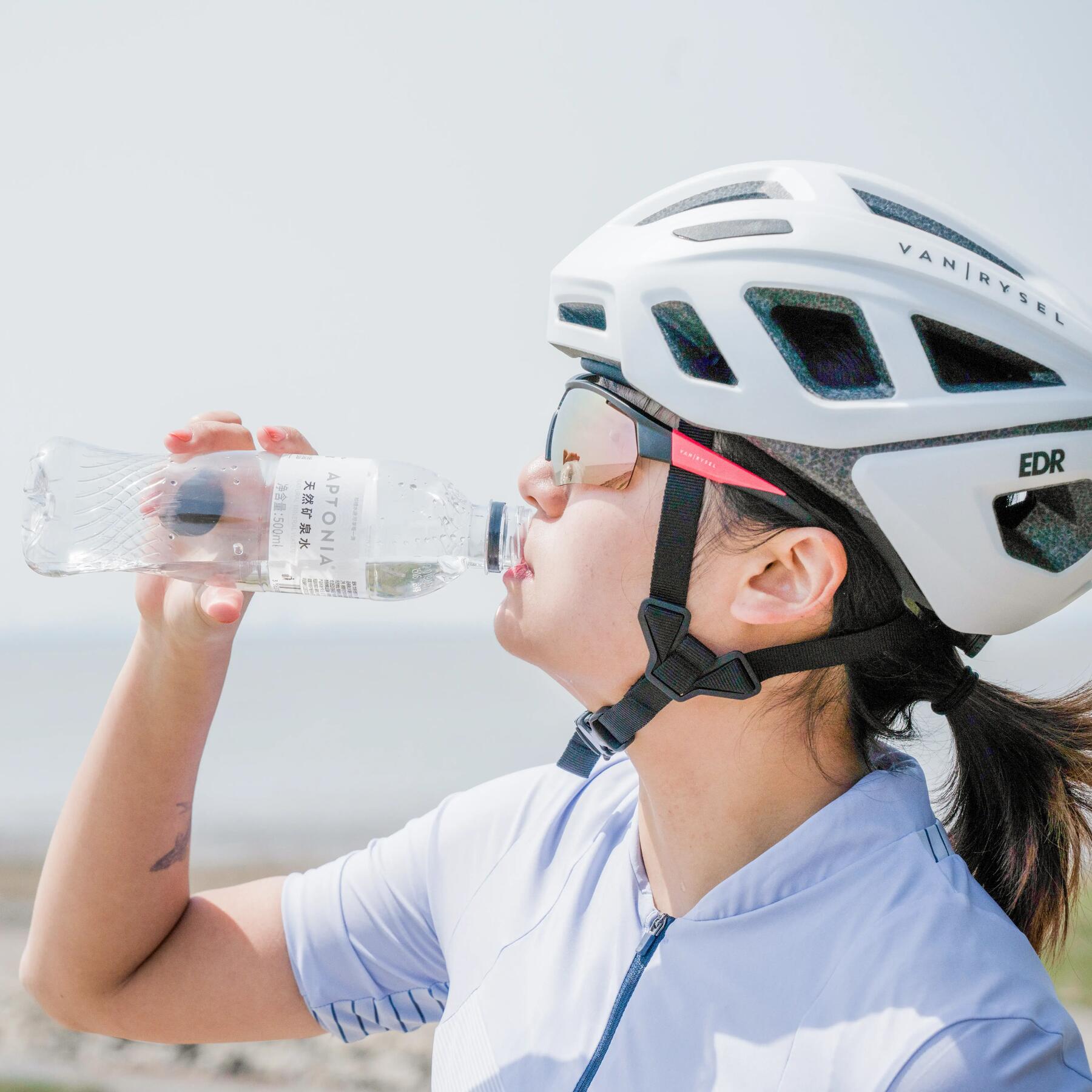 Kobieta pijąca izotonik podczas aktywności fizycznej aby pozbyć się nadmiaru wody z organizmu