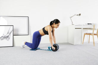 woman training at home with an ab wheel