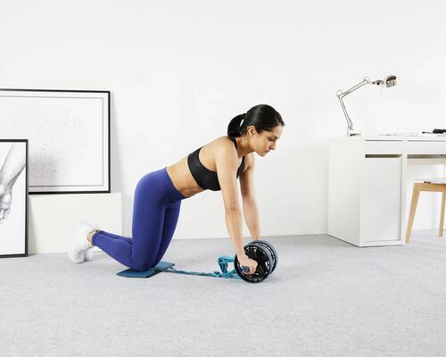 woman training at home with an ab wheel