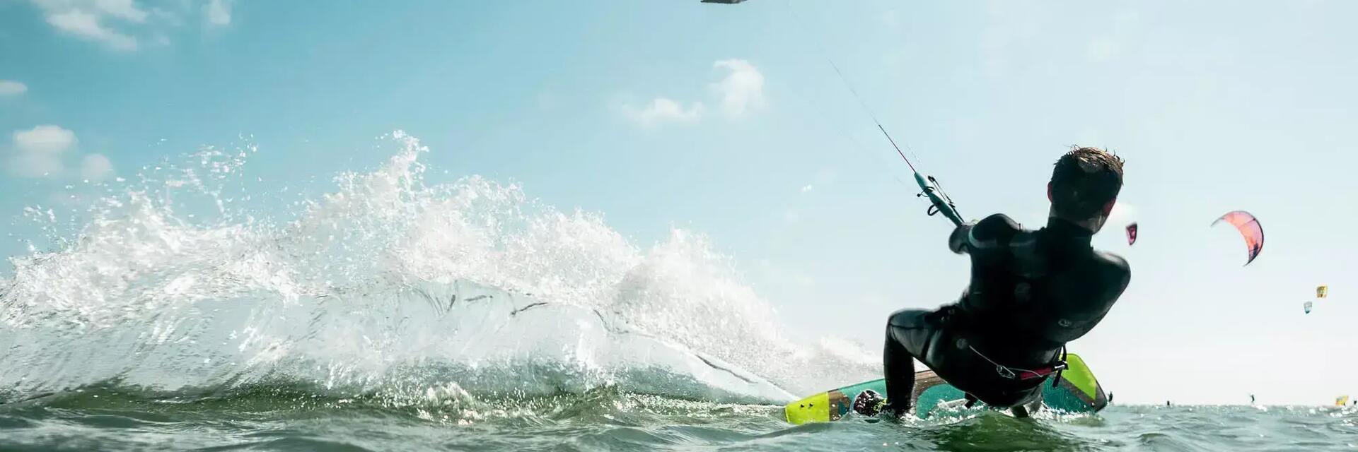 Kobieta w kasku ucząca pływać się na kitesurfingu
