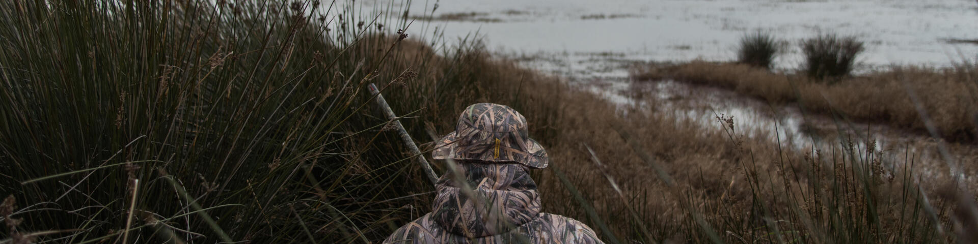 un chasseur chassant le gibier d'eau sur sa flaque