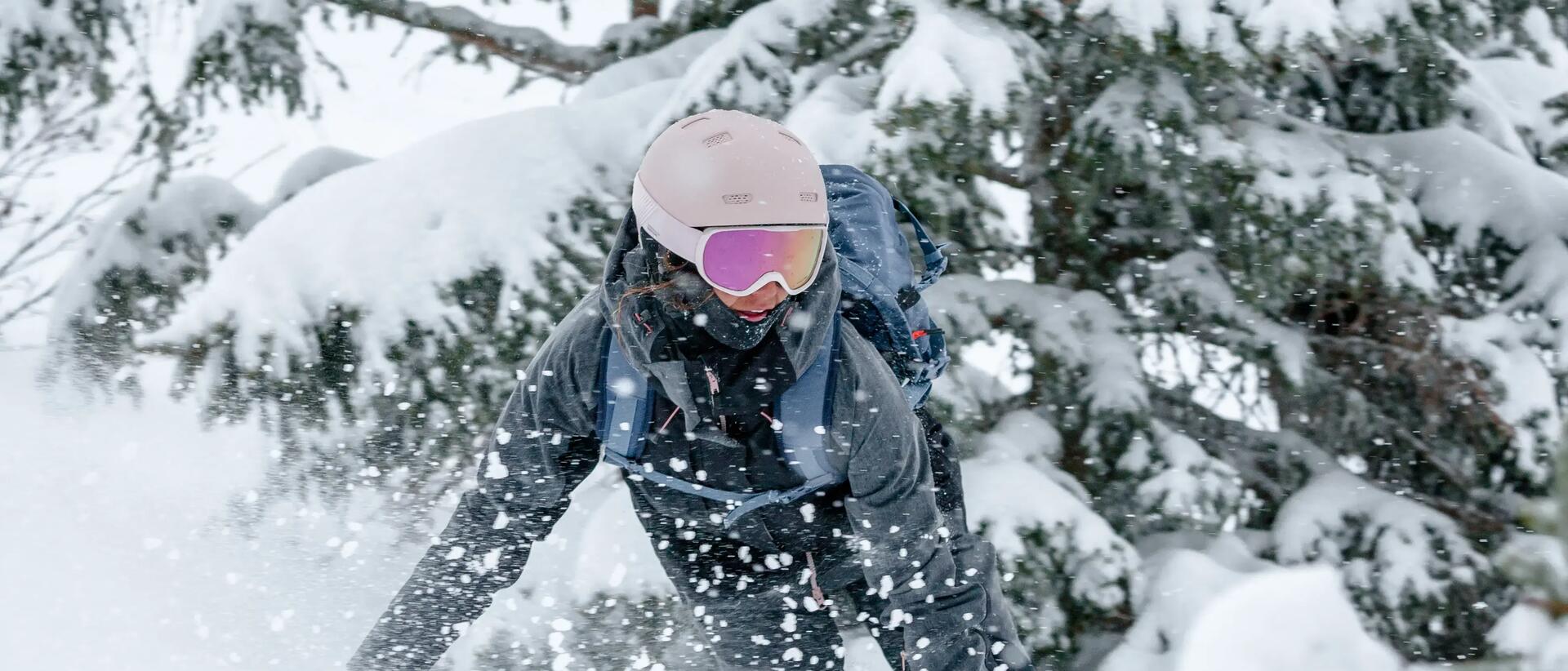 kobieta w kasku i goglach zjeżdżająca na desce snowboardowej 