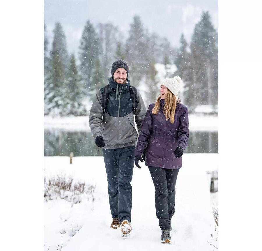 Mann und Frau laufen im Schnee nebeneinander