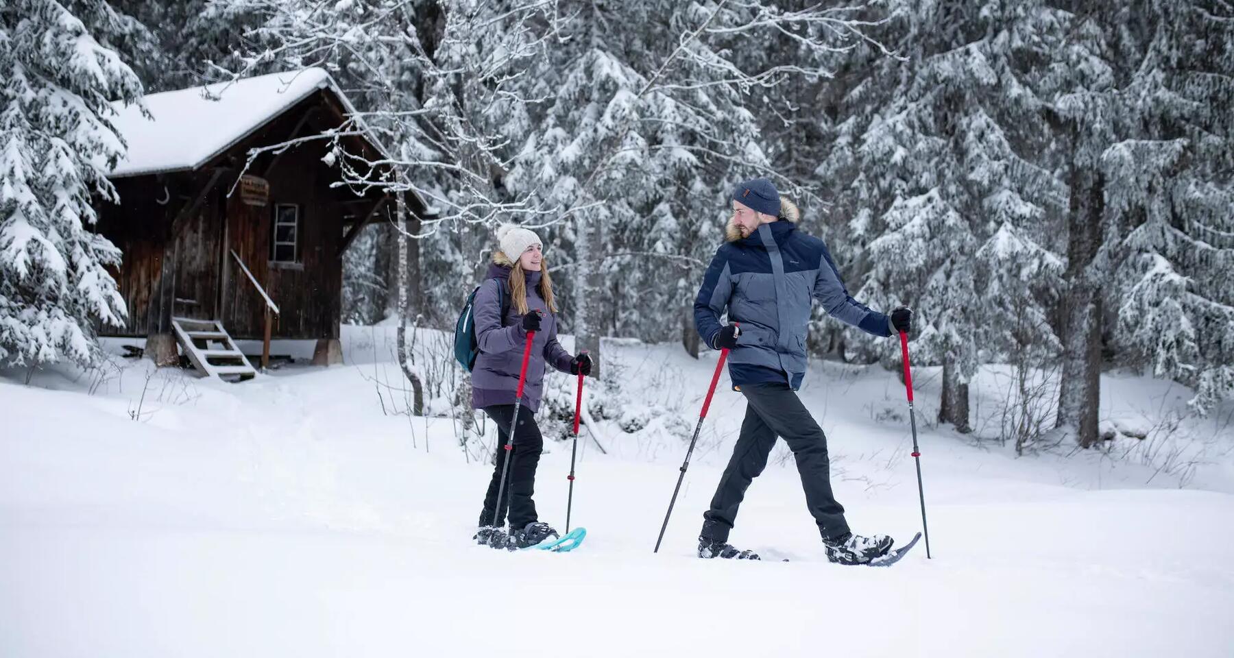 Zwei Menschen wandern im Schnee mit Skistöcken 