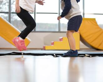 Duas crianças a saltar numa aula de ginástica