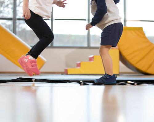 Duas crianças a saltar numa aula de ginástica