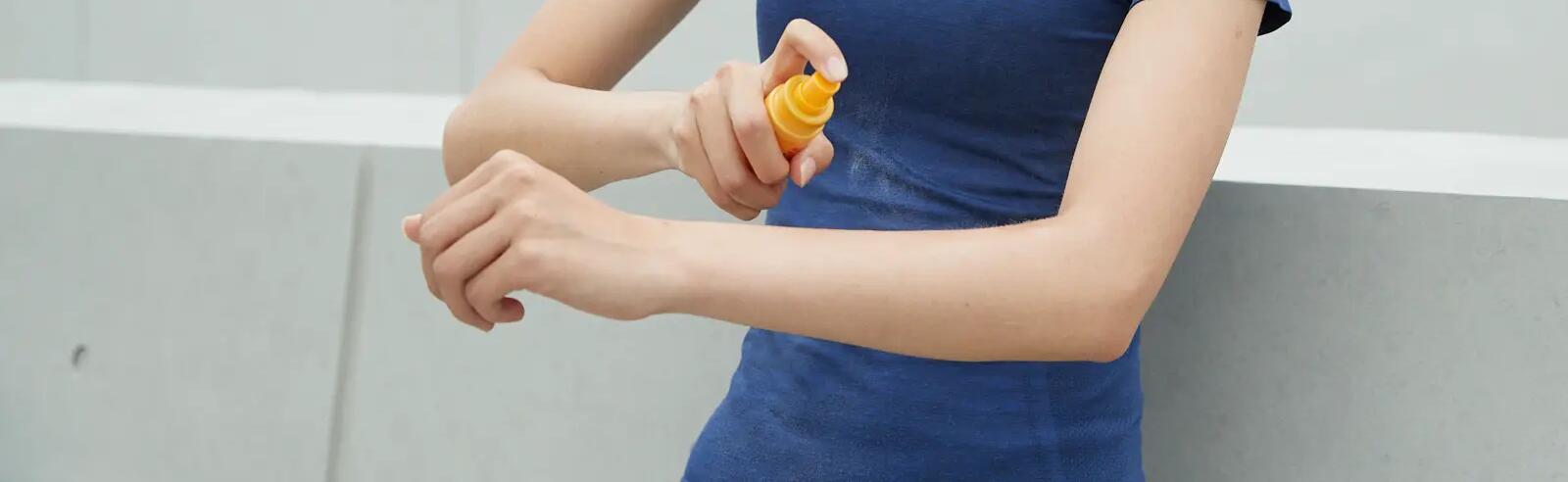 Une femme qui applique de la crème solaire sur son bras