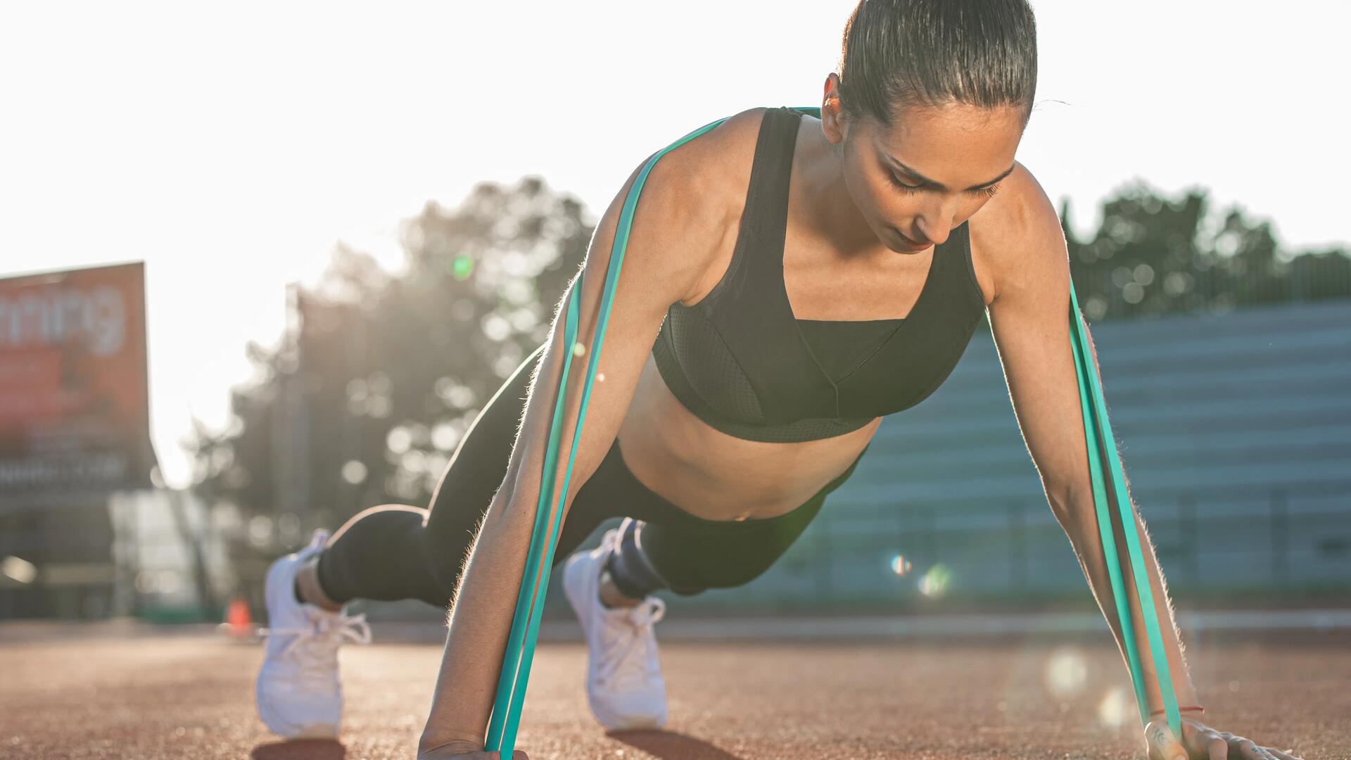 woman doing push-up with elastic band