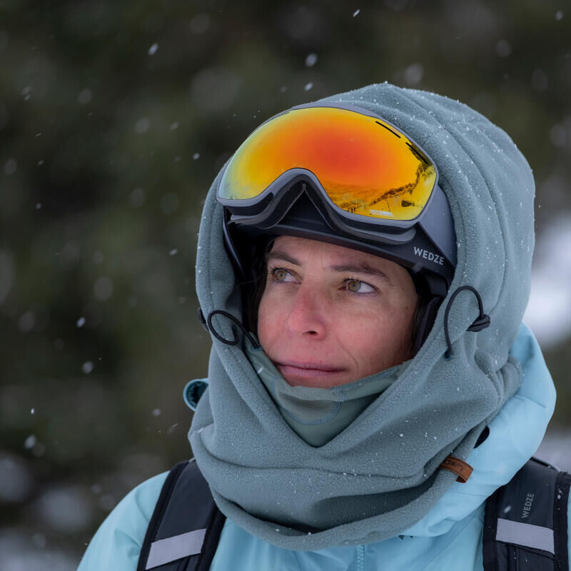 A woman looking at the ski slope with her glasses on her head