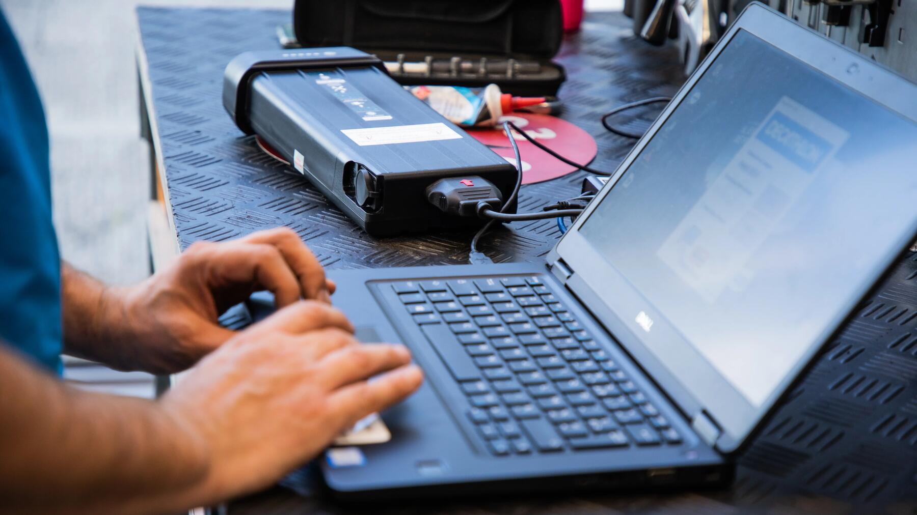 Een Decathlon-technicus werkt aan een elektrische fietsbatterij