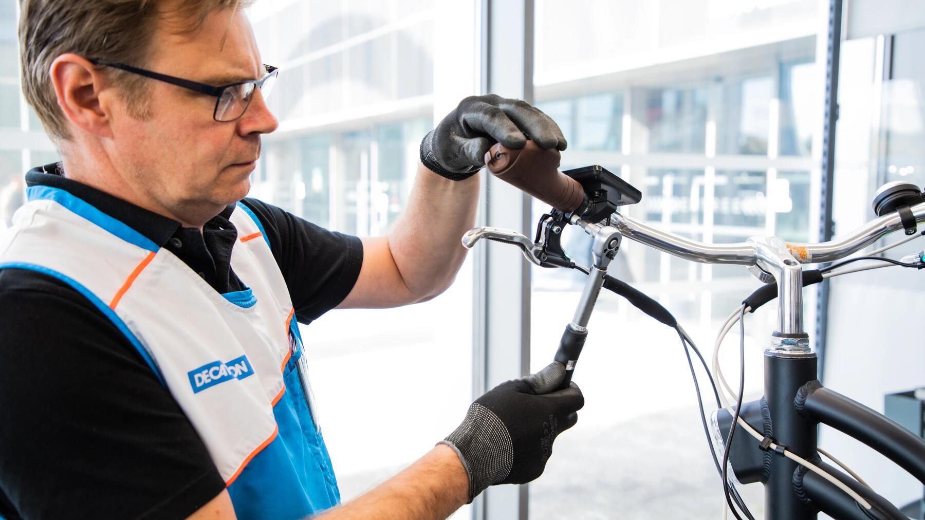 Decathlon medewerker die het stuur van een fiets verstelt