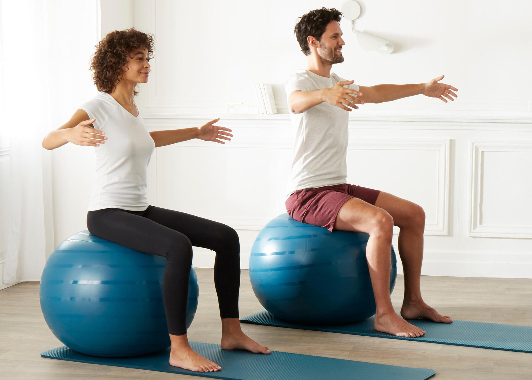 homem e mulher a fazer exercícios em bola de pilates