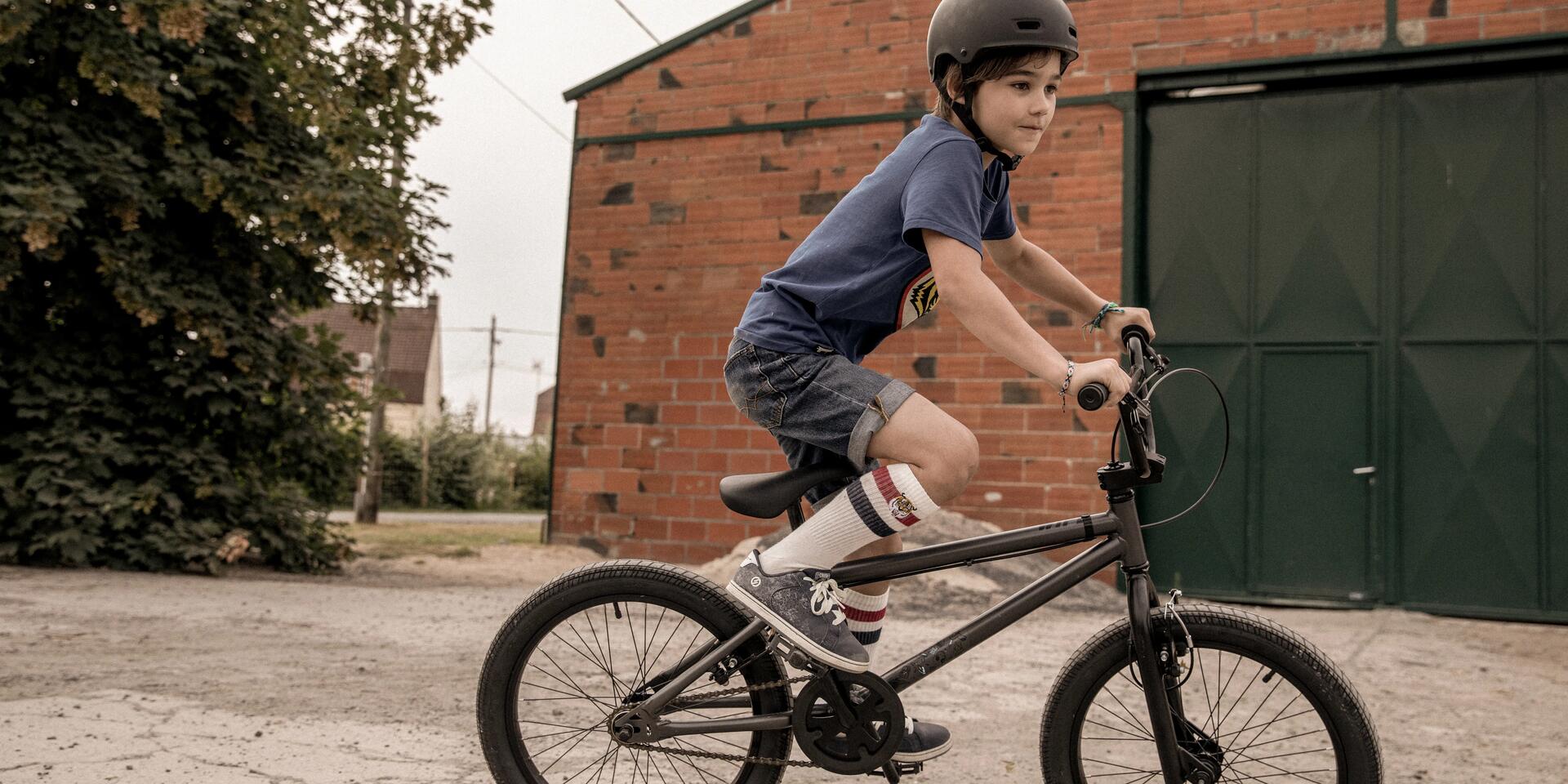 chłopiec jadący na rowerze w kasku rowerowym