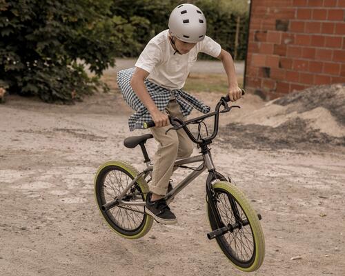 Kind fährt auf einem BMX mit Pegs