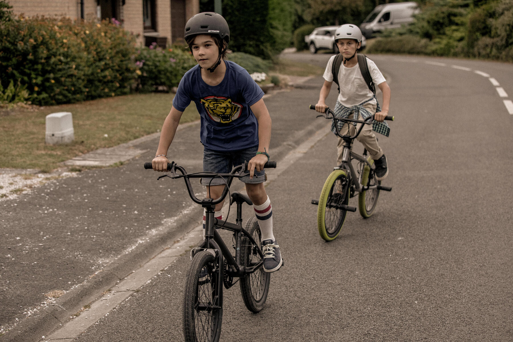 Dzieci w kaskach jadący na rowerach bmx