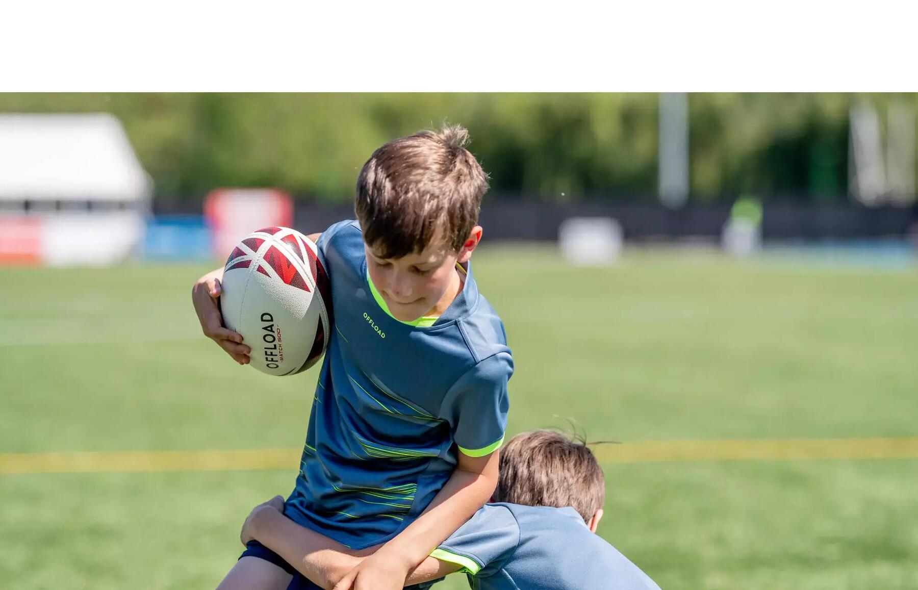 Two kids playing rugby outside