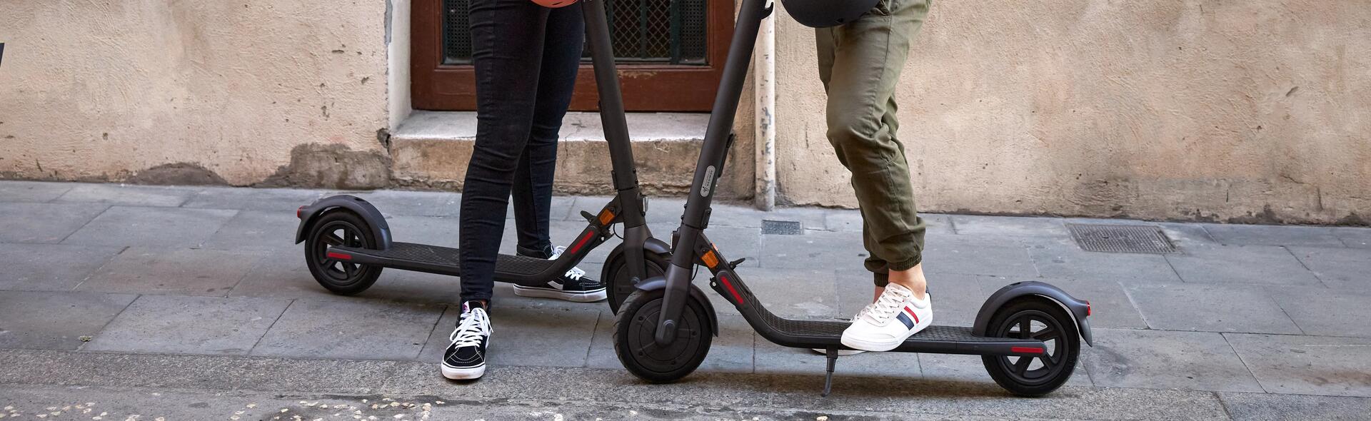 Two people scootering outside