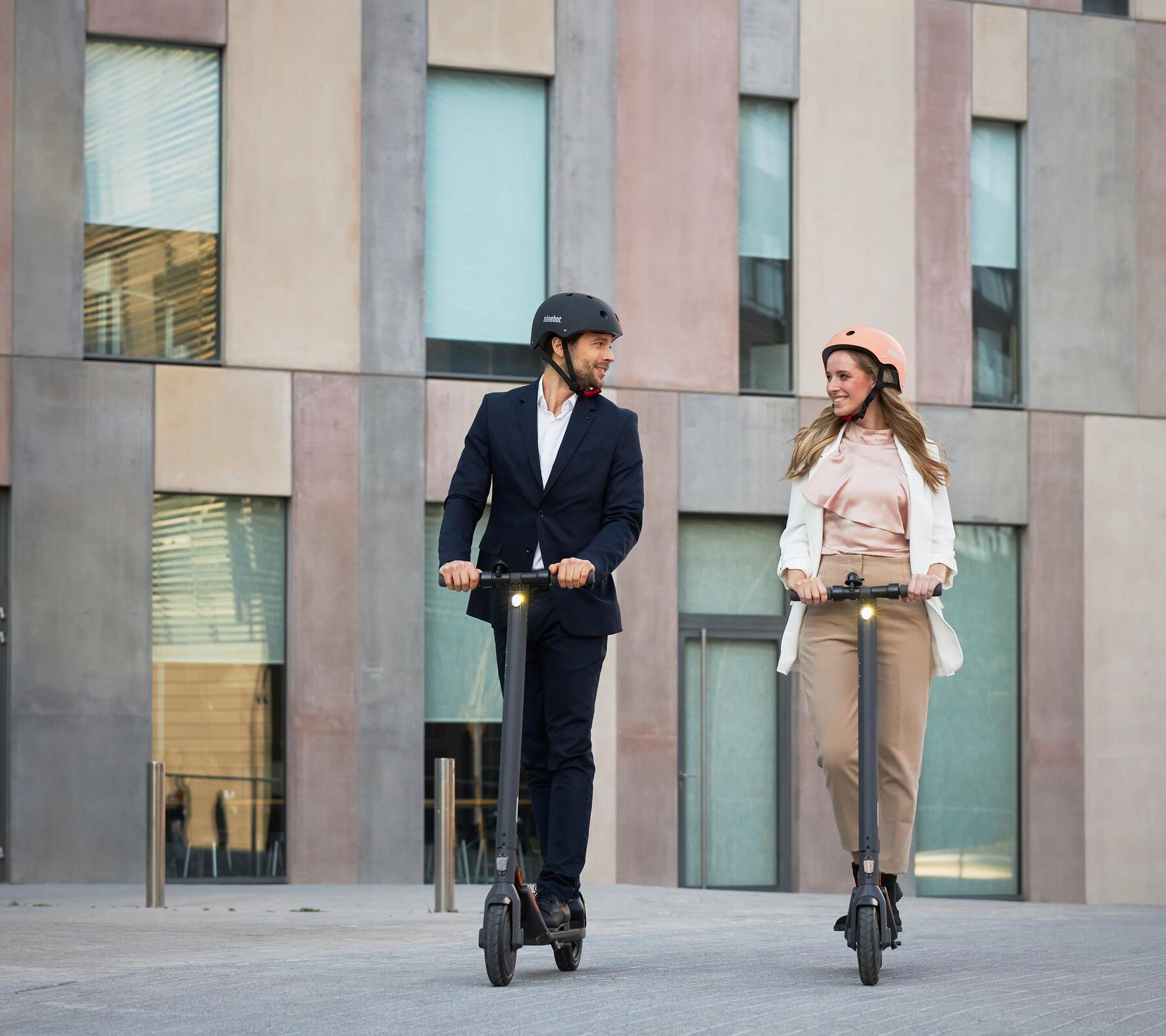 Man and woman scootering in city