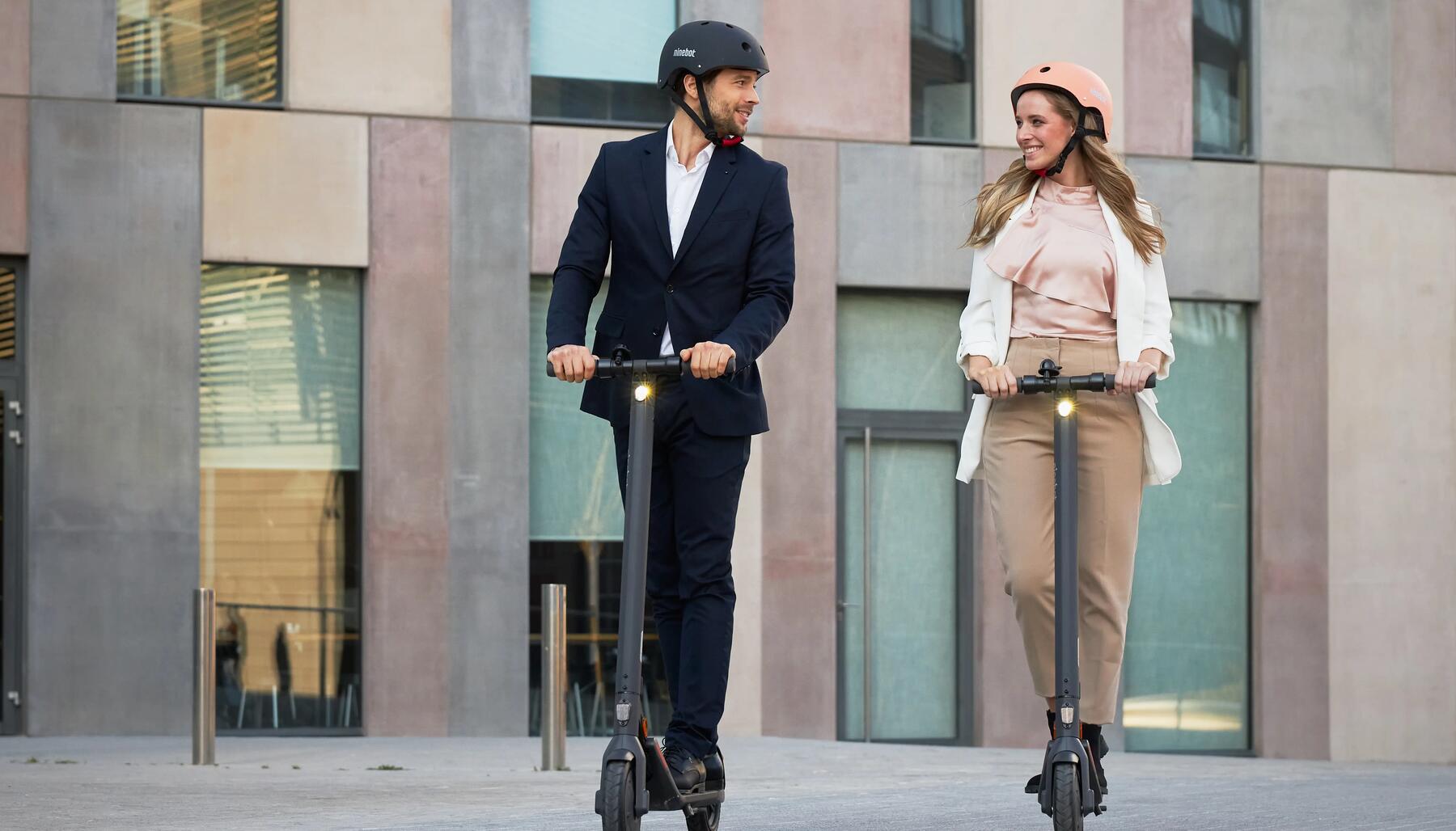 man and woman riding scooters 