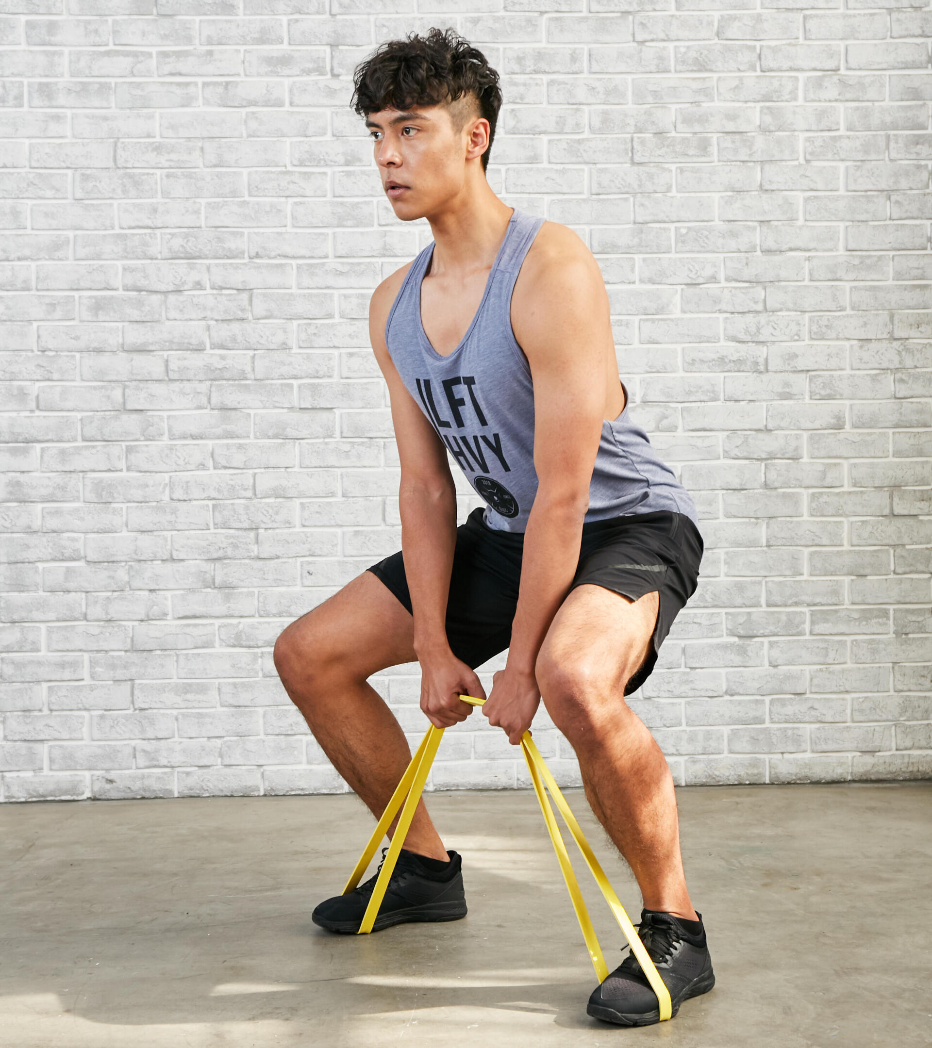 homem a fazer o exercício de agachamento com elástico de musculação e cross training corength